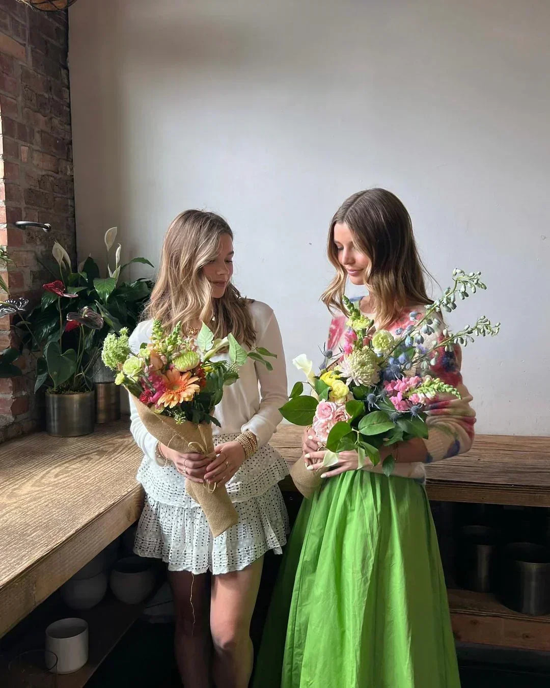 Couple holding handcrafted bouquets at the Flowers for Dreams Chicago studio after a flower-arranging experience.