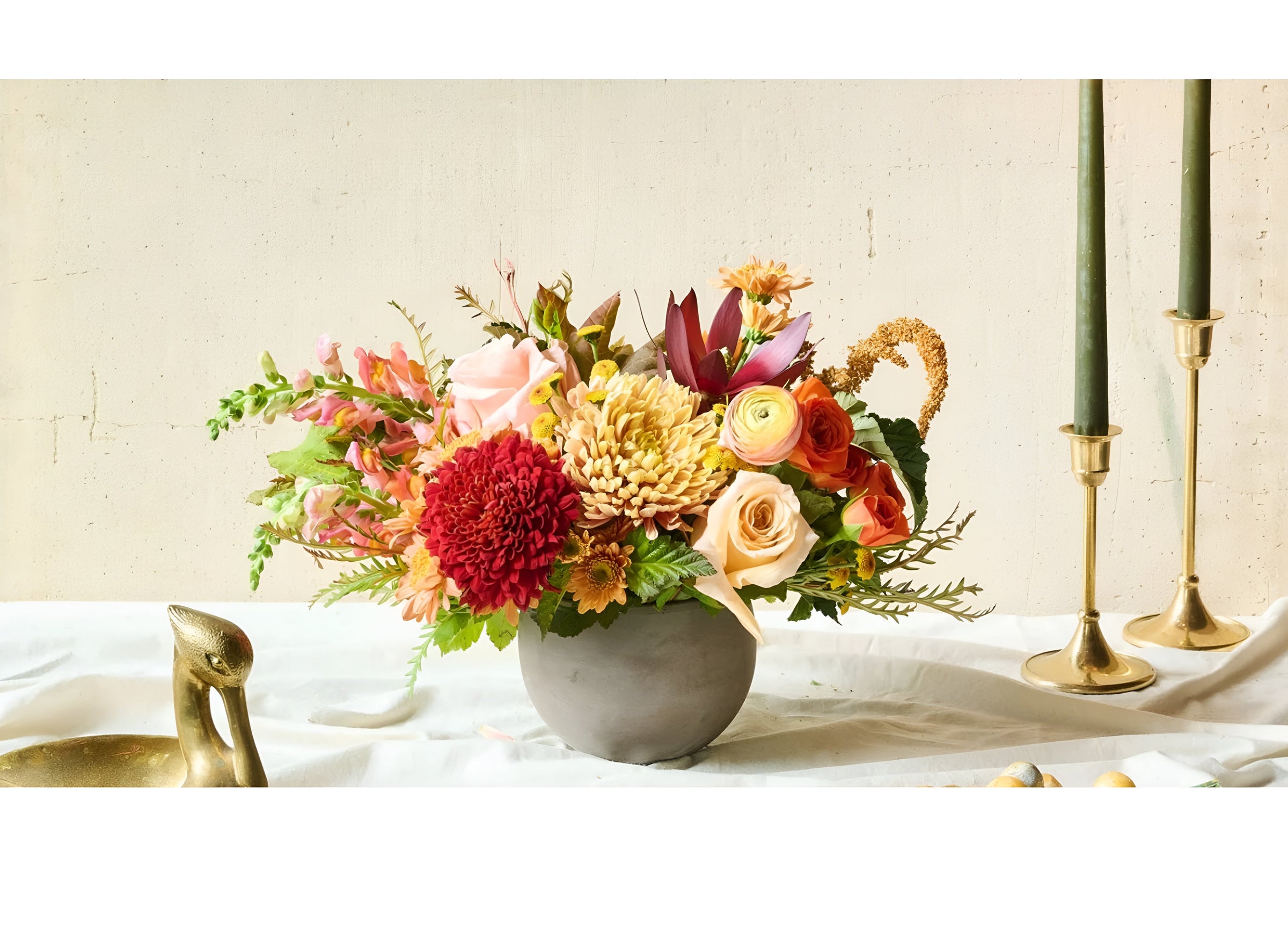 A rustic bouquet with bright roses, marigolds, hydrangeas, and delphin.