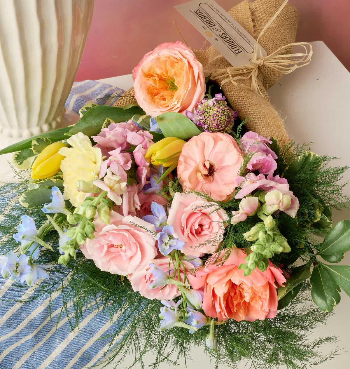 Peach garden roses, ranunculus, tulips, and scabiosa arranged organically in a signature May blend from Flowers for Dreams