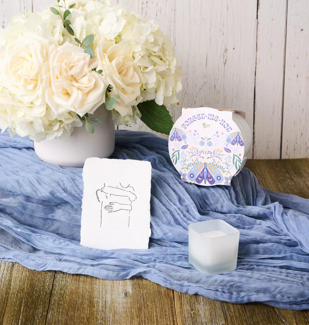 Flowers for Dreams’ sympathy bundle featuring an ivory bouquet and curated condolence items in soft, neutral tones.