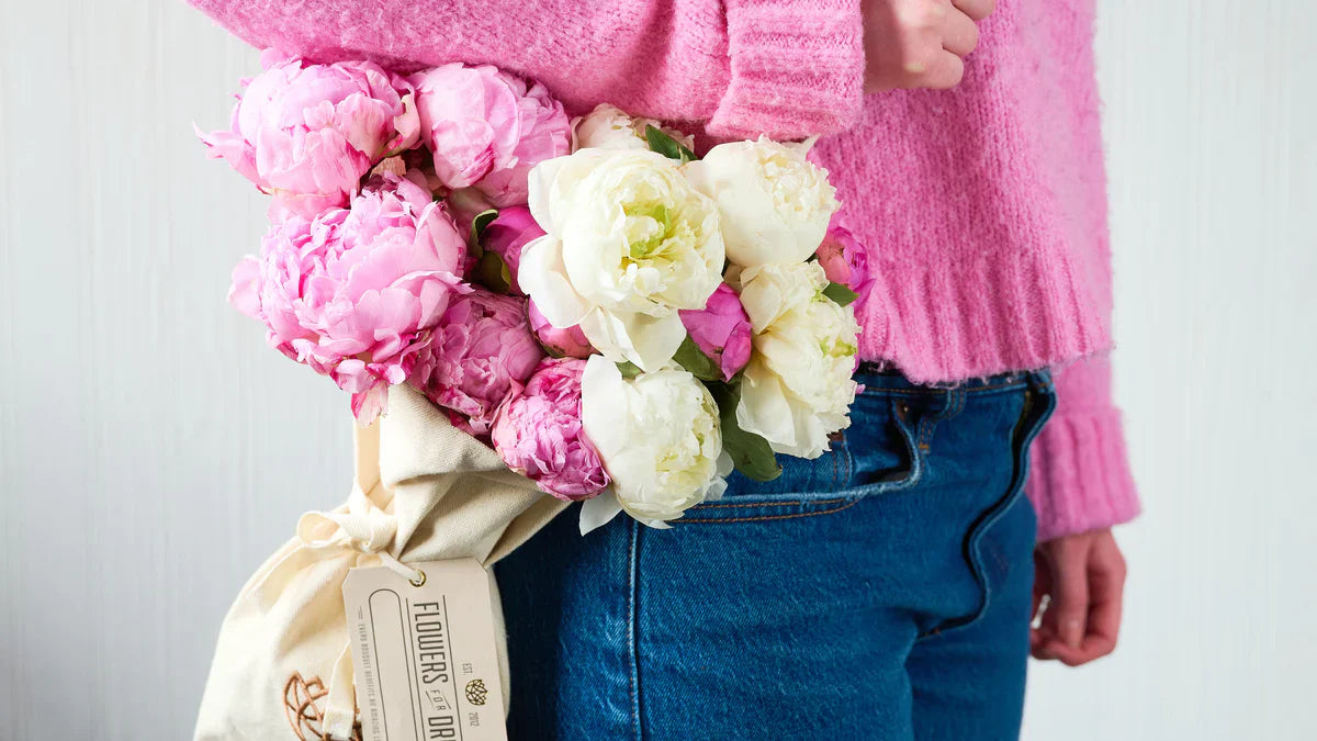 Woman holding Flowers for Dreams’ peonies bouquet under her arm.