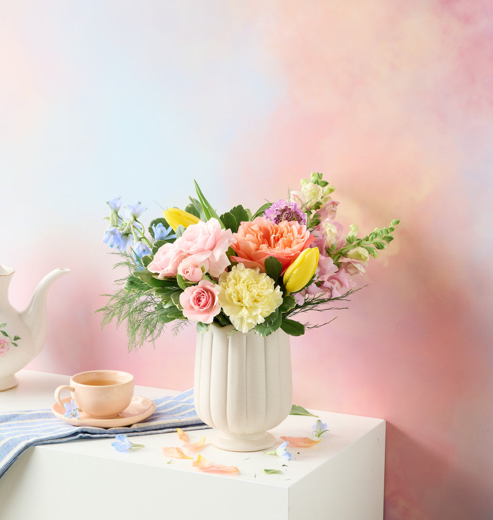 Spring floral arrangement in a vase with soft pastel background