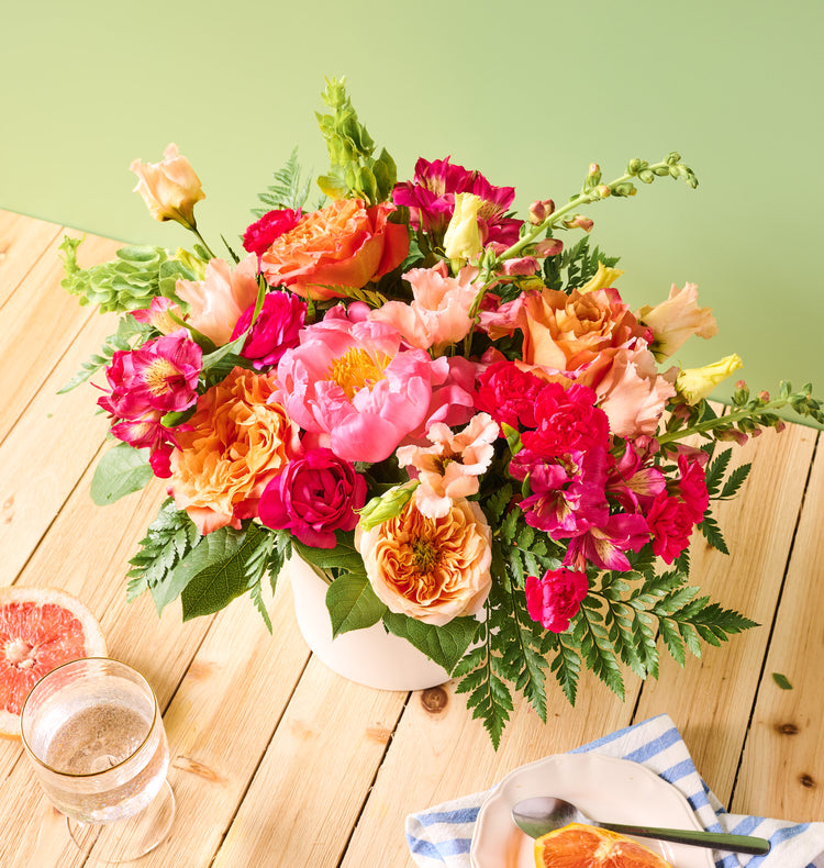 Large Summer arrangement in a decorative vase, warm blooms