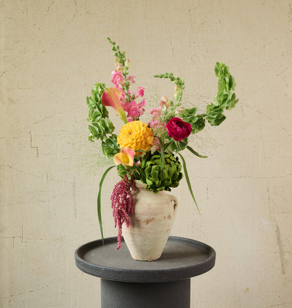 Artisan floral arrangement in a ceramic jug with rustic mixed blooms