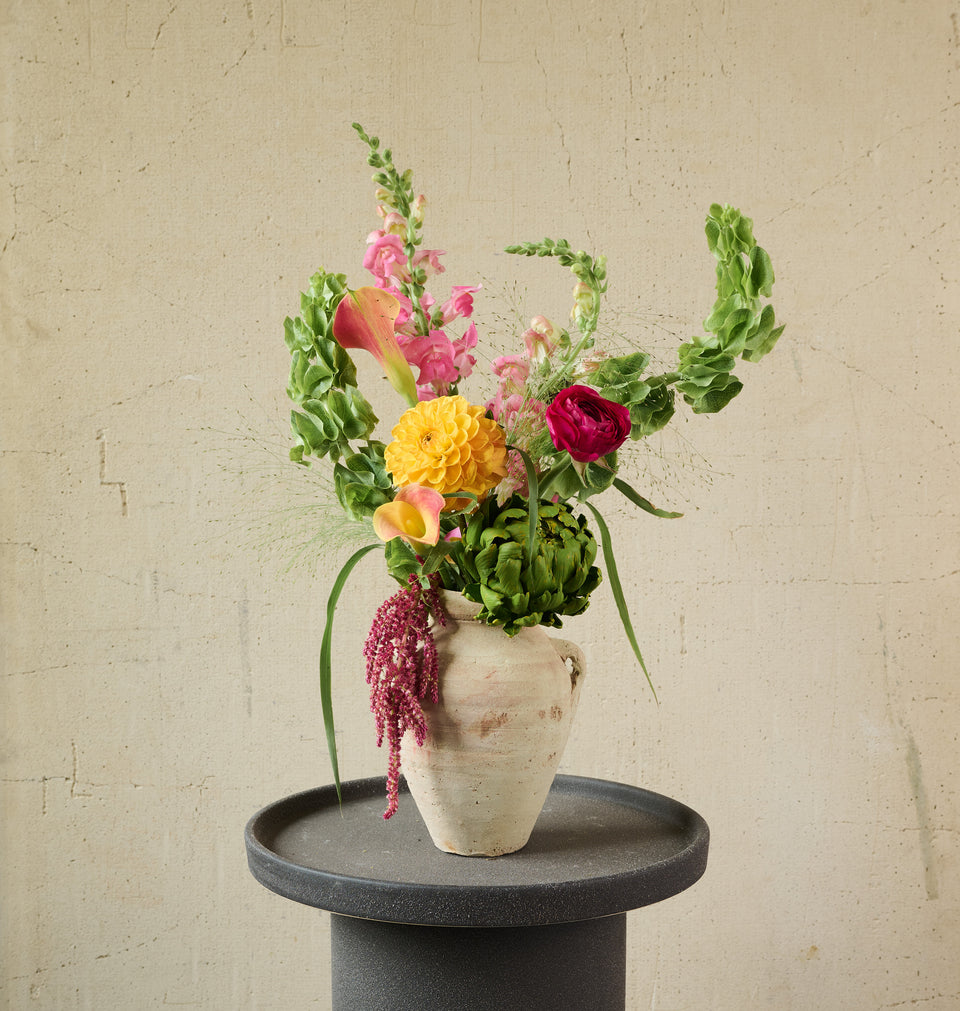 Artisan floral arrangement in a ceramic jug with rustic mixed blooms